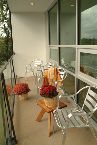 A modernist take on the front porch, this space connects to the home through a wall of windows, enhancing the indoor-outdoor connection and naturally shading the interior.